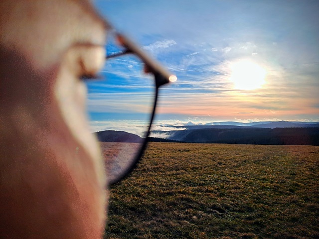 Horská krajina ve zapadajícím slunci pohledem skrze brýle na inverzi.
